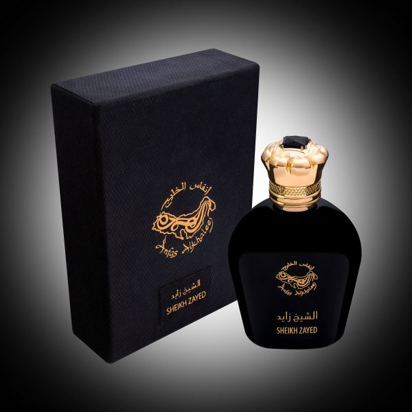 black perfume bottle with a gold cap next to a black leather box